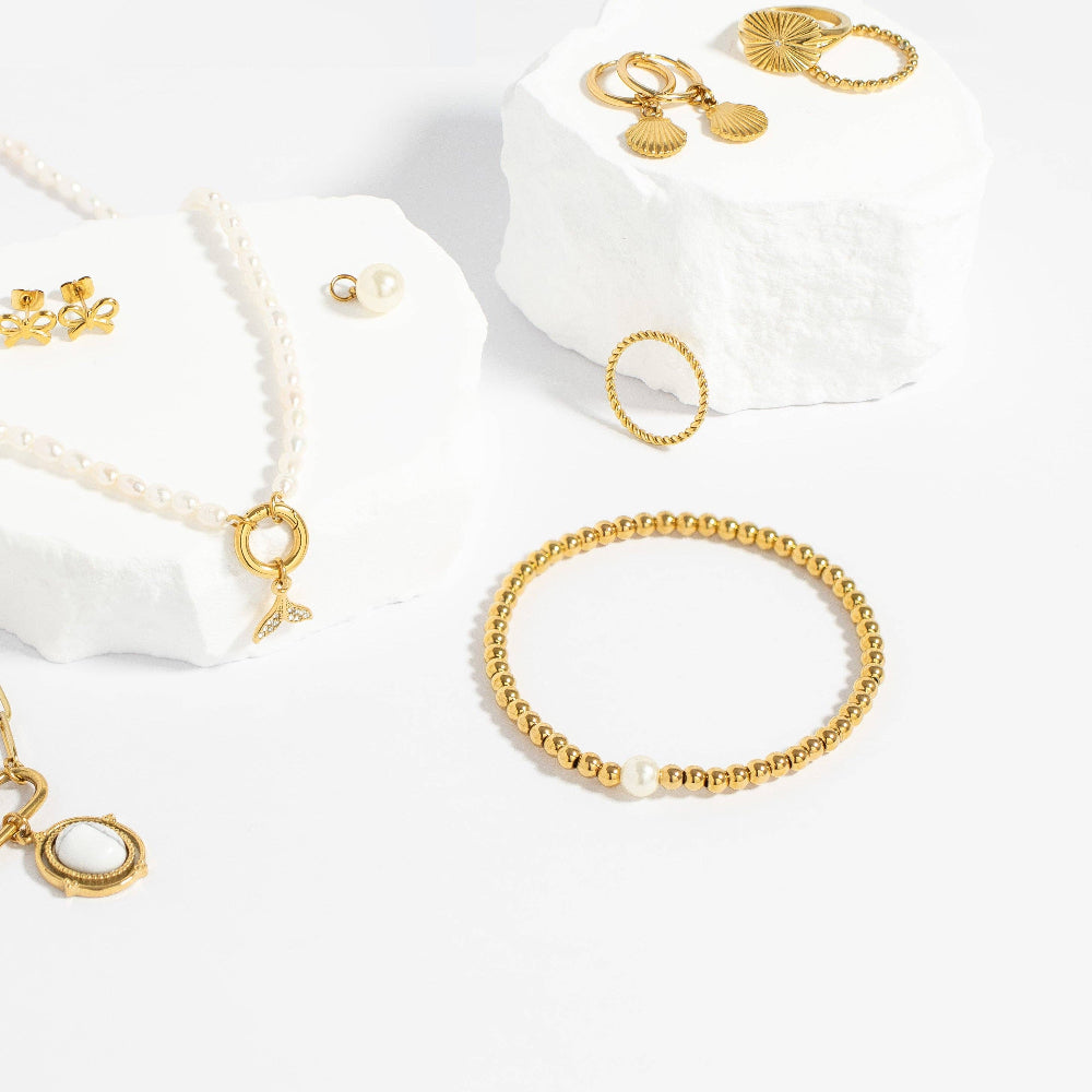 Gold jewelry set including bracelets, necklaces, and earrings on a white background