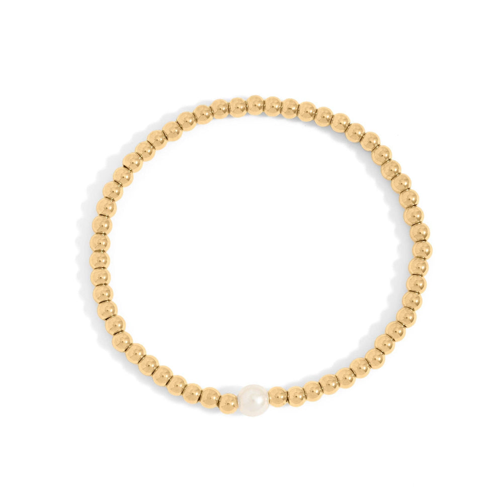 Gold beaded bracelet with a single pearl on a white background
