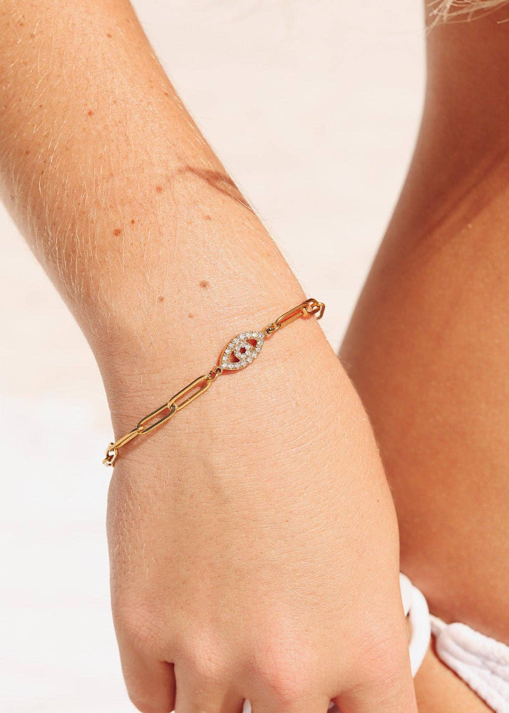 Rose gold bracelet with a diamond accent on a wrist against a light background